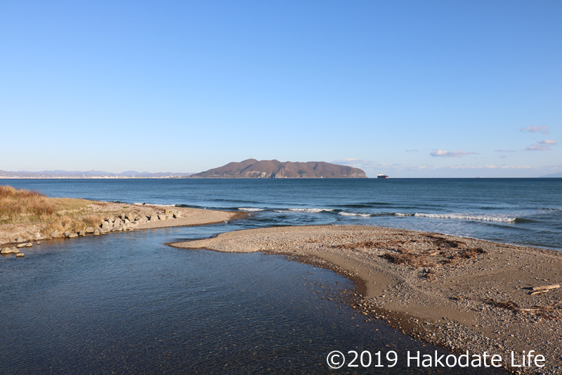 茂辺地川河口付近と函館山